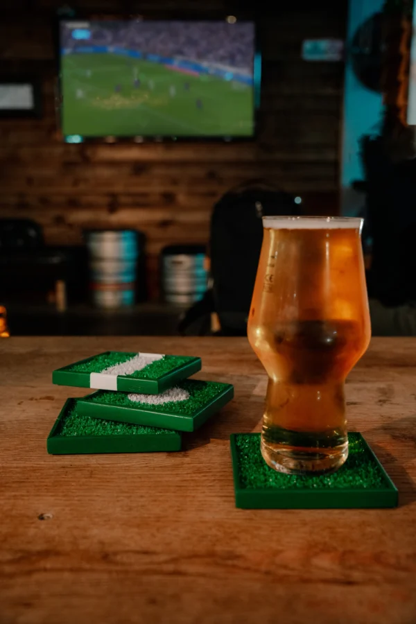 Four football cup coasters and a beer.