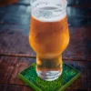 Beer standing on a football cup coaster.