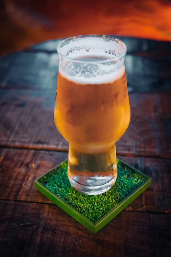 Beer standing on a football cup coaster.